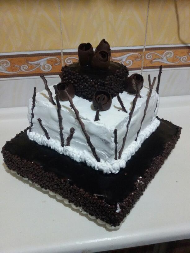 کیک اسفنجی با تزیین خامه و شکلات.