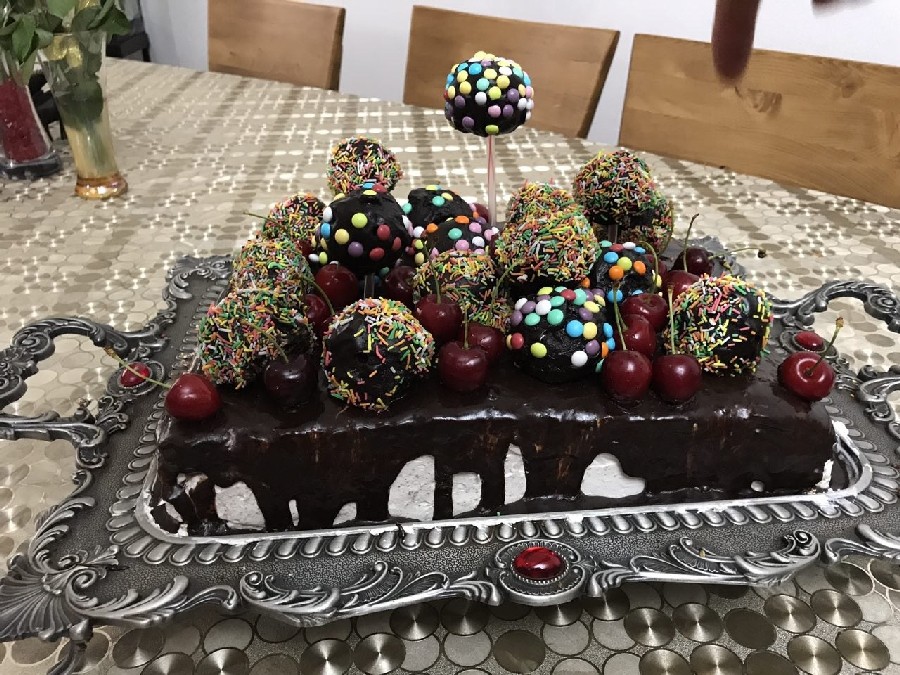 عکس کیک خامه ای با روکش گاناش با پاپ کیک های توپی