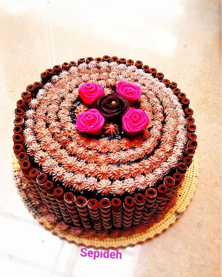 کیک با روکش گاناش و تزیین خامه و گل های شکلاتی و رول شکلات