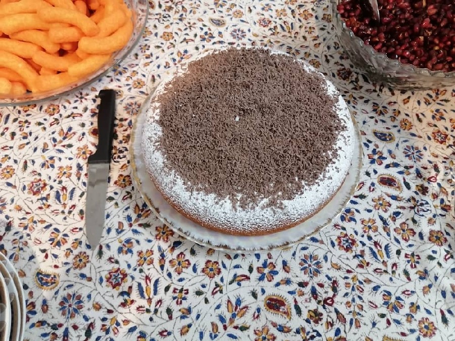 عکس کیک ساده وانیلی با تزیین پودر قند و شکلات رنده شده.
