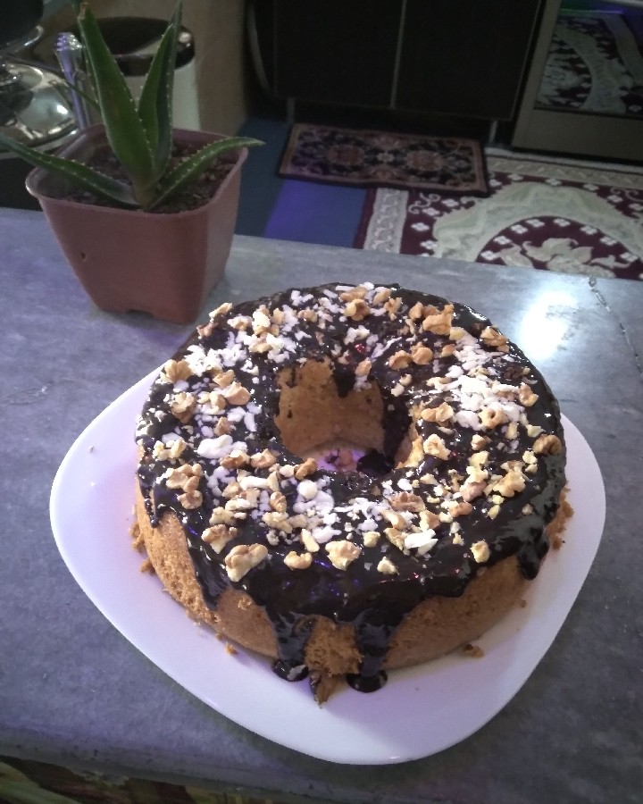 کیک اسفنجی با روکش شکلات بن ماری شده با تزیین گردو و شکلات سفید