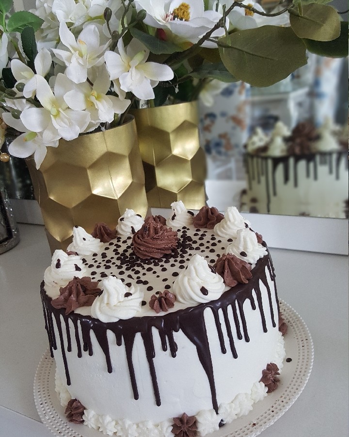 عکس کیک شکلاتی با تزیین خامه و شکلات