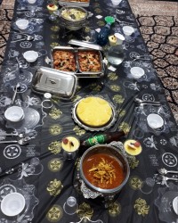 نمای کلی از سفره خورش قیمه بادمجان شکم پر چیز کیک مشکوفی سالادسزار خوراک مرغ زعفرانی